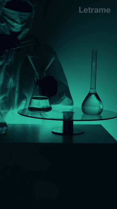 Laboratorio en penumbra verde con matraces